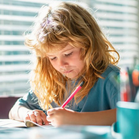 Photo for Child writing homework in school class. Preteen schoolboy doing her homework at home. Child study. Education and learning for kids. Cute little boy doing homework in classroom - Royalty Free Image