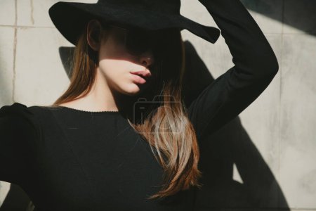 Foto de Estilo de moda de mujer. Hermosa chica sexy en sombrero con vestido casual caminando por la calle - Imagen libre de derechos