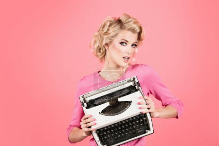 Foto de Sensual business woman, retro secretary office with vintage glasses and typewriter, accountant secretary. Beautiful young woman with pin-up make-up and hairstyle posing over pink background - Imagen libre de derechos