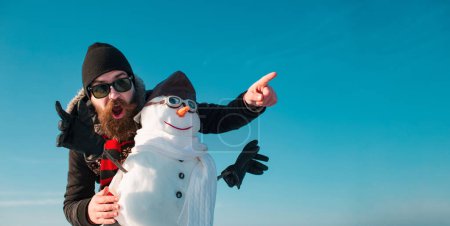 Téléchargez les photos : Homme drôle avec bonhomme de neige sur fond extérieur d'hiver. Bonhomme de neige pour bannière d'hiver - en image libre de droit