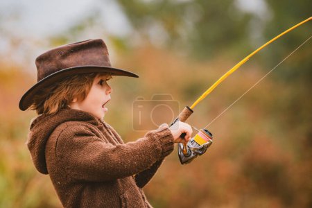 Foto de Emocionado niño pescando con carrete giratorio. Niños americanos y concepto de infancia feliz - Imagen libre de derechos