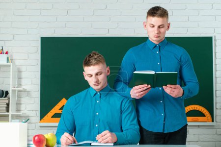Photo for Brother support. Twin boys in uniform on lesson. Brothers in college or university - Royalty Free Image