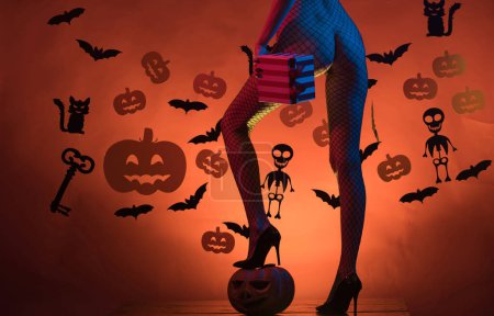 Téléchargez les photos : Vacances Halloween avec des costumes de carnaval drôles sur un fond d'Halloween. Les bonbons les plus populaires pour Halloween. Chapeau de sorcière. Fond décoré pour Halloween - en image libre de droit