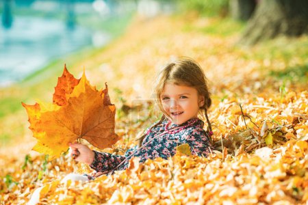 Foto de Mujer linda niña en el parque de otoño. Hojas cayendo. Estado de ánimo del niño de otoño - Imagen libre de derechos