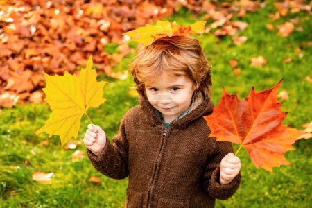 Foto de Otoño retrato al aire libre de hermoso niño feliz caminando en el parque o el bosque en caliente Ropa de otoño - Imagen libre de derechos