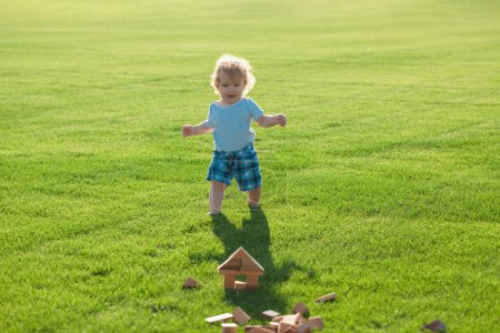 Photo for Insurance kids. Happy childhood. Little baby learning to crawl steps on the grass. Concept childrens months. Happy child playing on green grass playground - Royalty Free Image