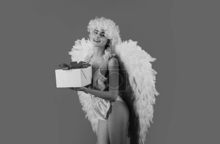 Foto de Mujer ángel con alas blancas plumas y regalo. Maravillosa chica ángel rubia con alas blancas. Foto de arte de una mujer hermosa angelical - Imagen libre de derechos