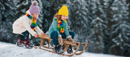 Photo for Cute girl and boy enjoying a sleigh ride. Children sledding in snow on winter park - Royalty Free Image