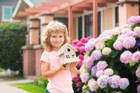Photo for Kid child dreaming of new home. Happy boy holding dream house in their hands, real estate and home insurance concept - Royalty Free Image