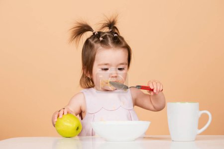 Photo for Baby child eating food. Little baby eating fruit puree - Royalty Free Image