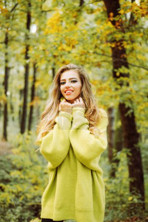 Photo for Cute girl in good mood posing in autumn day. Outdoor fashion photo of young beautiful lady surrounded autumn leaves. Cheerful beautiful girl in sweater outdoors on beautiful fall day. Fall concept - Royalty Free Image