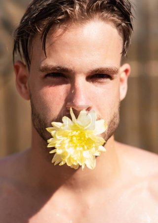Photo for Man in love. Pride gay homosexual concept. Man face with flower in mouth, tongue. Handsome man close-up portrait - Royalty Free Image