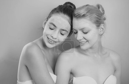 Photo for Friendly young beautiful girls with bare shoulders apply organic face mask and smile. Blond and dark hair women make skincare. Friendship and young natural beauty concept - Royalty Free Image