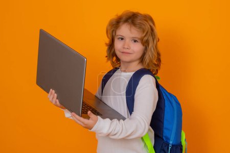 Téléchargez les photos : Des écoliers. Un écolier qui utilise un ordinateur portable. Un écolier de 7-8 ans avec PC retourne à l'école. Petite étudiante, élève - en image libre de droit