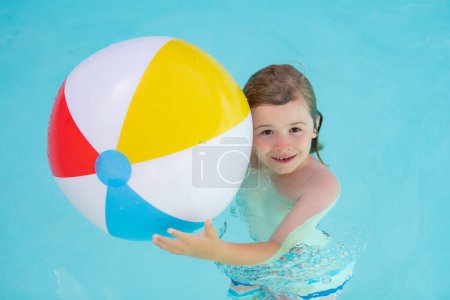 Photo for Kid hold rubber air ball in pool. Happy child having fun on summer vacation. Kid playing with ball in the swimming pool. Kid play with floating ball in sea water. Summer vacation - Royalty Free Image