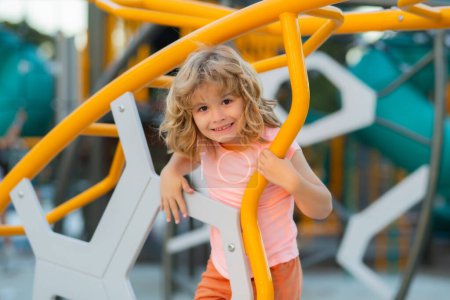 Téléchargez les photos : Little boy playing on the playground. The emotion of happiness, fun, joy. Smile of a child - en image libre de droit