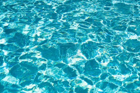 Téléchargez les photos : Ondulation Eau dans la piscine avec réflexion du soleil. Fond d'eau ondulée - en image libre de droit