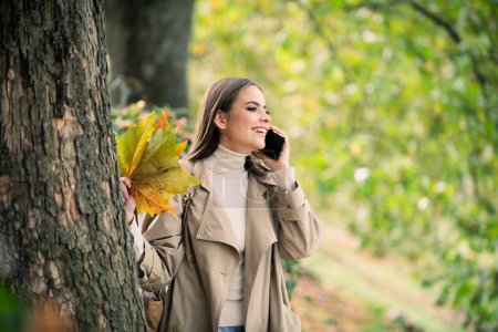 Photo for Autumn woman with fall yellow maple leaf, outdoor portrait. Beautiful model with autumn leaves, fall yellow maple in autumnal park. Autumn girl enjoying warm sunny weather in autumn fall season - Royalty Free Image