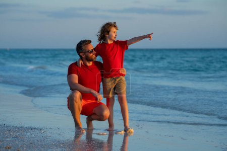 Foto de Día de los Padres. Padre caminando con un pequeño hijo en la playa cerca del mar. Papá con su hijo caminando en una playa de verano. Los padres aman a los niños. Padre e hijo relajándose en el mar. Vacaciones de verano, vacaciones con padre - Imagen libre de derechos
