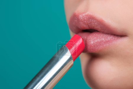 Photo for Red lipstick. Glossy make-up for plump natural lips. Lipstick and pomade. Close up red lips. Pink lipstick. Pomade. Applying lipstick. Make up in process - Royalty Free Image