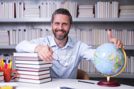 Photo for Happy portrait of teacher in library classroom. Handsome teacher in university library. Teachers Day. Teacher giving classes. School teacher in library. Tutor in classroom at college library - Royalty Free Image