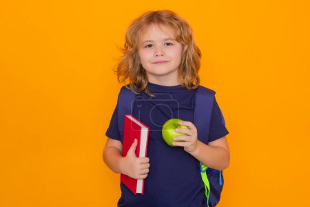 Photo for Pupil, nerd schoolboy. School boy with book and apple. School child student learning. Elementary school child. Portrait of funny pupil learning on yellow isolated background - Royalty Free Image