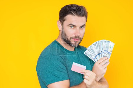 Photo for Man holding cash money in dollar banknotes on isolated yellow background. Studio portrait of business man with bunch of dollar banknotes. Dollar money concept. Career wealth business. Cash dollar - Royalty Free Image