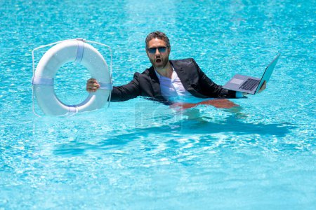 Photo for Helping summer business. Businessman in suit hold laptop and lifebuoy in sea beach water. Rescue businessman. Helping businessman. Save business. Summer crisis. Crazy summer. Hot business summer - Royalty Free Image