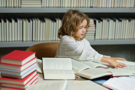Photo for Education Concept. Child reads books in the library. Schoolkid with book in school library. Kids literature for reading. Learning from books. School education and clever talented pupil genius - Royalty Free Image