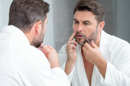 Téléchargez les photos : Un homme avec des ciseaux de coiffeur. Homme couper les cheveux avec des ciseaux de coiffure. Des hommes coiffés dans un salon de coiffure. Ciseaux de coiffeur. Une coupe de cheveux masculine. Barbier tenant des ciseaux. Des outils de coiffeur. Salon de coiffure - en image libre de droit