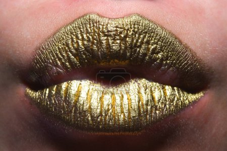 Téléchargez les photos : Gold lips, golden lipgloss on sexy lips, metallic mouth. Beauty woman mouth. Sexy girl golden lips, gold mouth. Glowing gold skin and gild lips. Metallic shine golden lip gloss - en image libre de droit