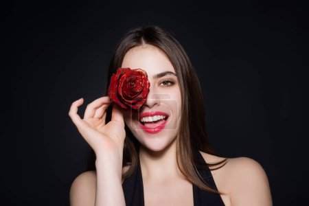 Téléchargez les photos : Jolie femme, avec des lèvres rouges, et un maquillage de mode avec des roses posant en studio. Beauté et portrait de mode - en image libre de droit