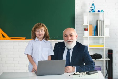 Photo for Teacher and child in classroom. Education concept. School learning concept. Boy elementary school. Old and Young - Royalty Free Image