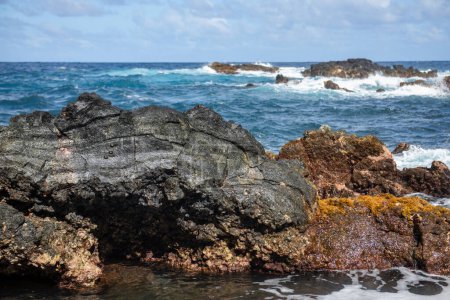 Téléchargez les photos : La mer bleue et les rochers prennent d'assaut. Vague pulvérisation sur les rochers. Côte rocheuse - en image libre de droit