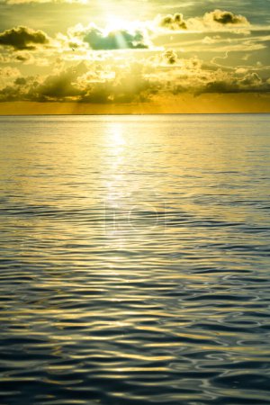 Foto de Puesta de sol en la playa tropical mar océano con nubes del amanecer. Banner para vacaciones de viaje. Paisaje cielo y reflejos rayos en el agua. Crepúsculo, crepúsculo en el mar. Puesta de sol sobre el mar con el panorama dramático dorado del cielo - Imagen libre de derechos