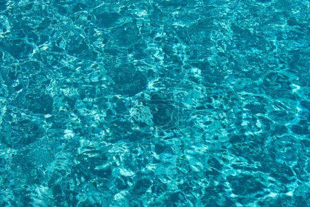 Téléchargez les photos : Bleu fond d'eau de piscine. Texture floue transparente et claire de la surface de l'eau calme. Vagues d'eau au soleil avec espace de copie - en image libre de droit