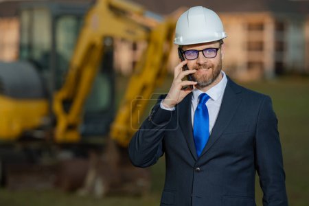 Photo for Construction builder manager or supervisor at a construction site. Portrait of construction manager worker in hardhat and suit near excavator. Renovation with construction manager or supervisor - Royalty Free Image