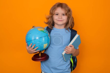 Photo for Knowledge day. School pupil with world globe and book. School kid student learning, study geography or literature at school. Elementary school child. Studio portrait of nerd pupil studying - Royalty Free Image