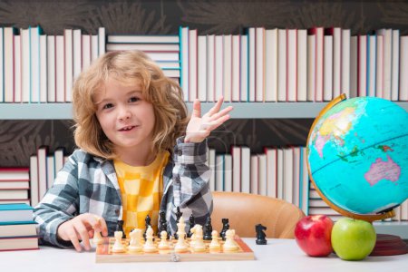 Téléchargez les photos : L'école d'échecs. Un gamin qui joue aux échecs. Un enfant intelligent qui pense aux échecs. Développement précoce des enfants - en image libre de droit