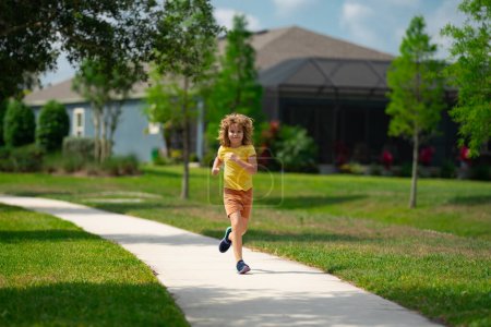 Téléchargez les photos : Enfant courant dans la rue d'été. Amuse-toi bien. Le gamin court dans le quartier. Les enfants courent sur la route de la ville. Bonne enfance. Un enfant qui court dans le parc. Sport et fitness, exercice pour les enfants - en image libre de droit