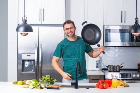 Photo for Chef cook cooking with pan at kitchen. Chef cook prepares with pan. Chef cooking with pan in modern kitchen. Mature chef man hold pan standing in kitchen, preparing food - Royalty Free Image