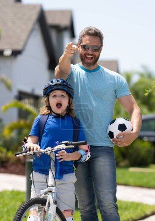 Photo for Fathers day. Father teaching son ride a bicycle. Father and son cycling on bike on summer day. Sporty family. Excited father and son winning gesture. Father support child. Fathers love. Sporty kids - Royalty Free Image