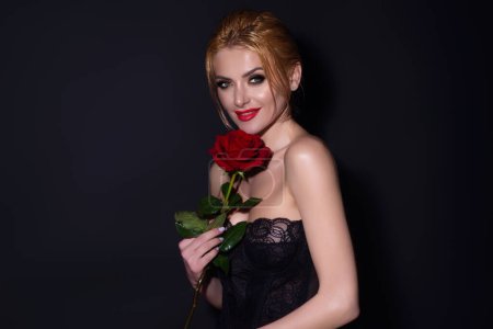 Foto de Día de San Valentín, celebración y concepto de belleza. Encantadora joven romántica con flores, fondo de estudio - Imagen libre de derechos