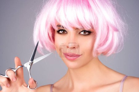 Photo for Beautiful woman with hairdresser scissors cutting hair - Royalty Free Image