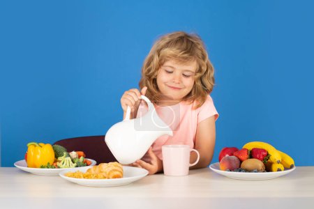 Photo for Kid having a breakfastand pouring milk. Child drink dairy milk - Royalty Free Image