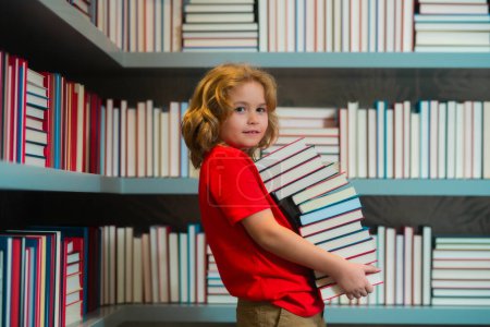 Photo for Education Concept. Little student on school library. Kid reading book at school. Nerd pupil. Clever intelligent schoolboy overwork. Smart child learning to read book - Royalty Free Image