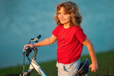 Photo for Happy kid boy riding bike in summer park. Bike dream. Dreamy kids face. Daydreamer child portrait close up. Dreams and imagination - Royalty Free Image