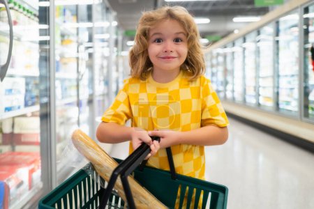Téléchargez les photos : Enfant dans un magasin d'alimentation ou un supermarché. Un gamin qui va faire du shopping. Aliments sains pour enfants - en image libre de droit