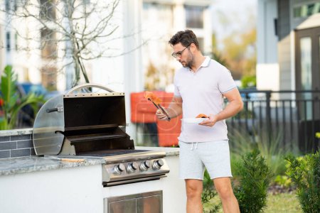 Photo for Handsome man preparing barbecue. Male cook cooking meat on barbecue grill. Guy cooking salmon fillet on barbecue for summer family dinner at the backyard of the house - Royalty Free Image