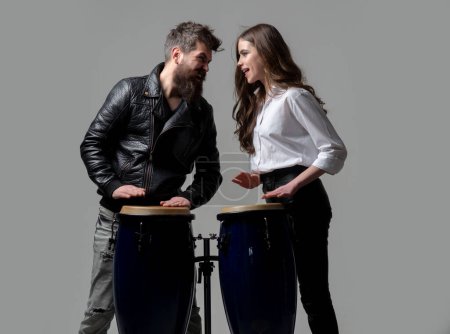 Téléchargez les photos : Homme et femme jouant de la batterie conga. Couple excité frappant sur des tambours conga isolés sur fond gris - en image libre de droit